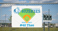 Custom school banner hanging on athletic field fence