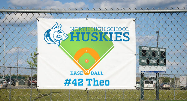 Custom school banner hanging on athletic field fence